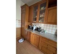 Cucina in legno con elettrodomestici tavolo e sedie