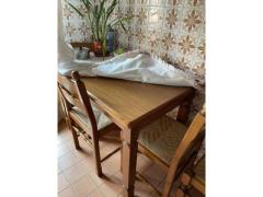 Cucina in legno con elettrodomestici tavolo e sedie